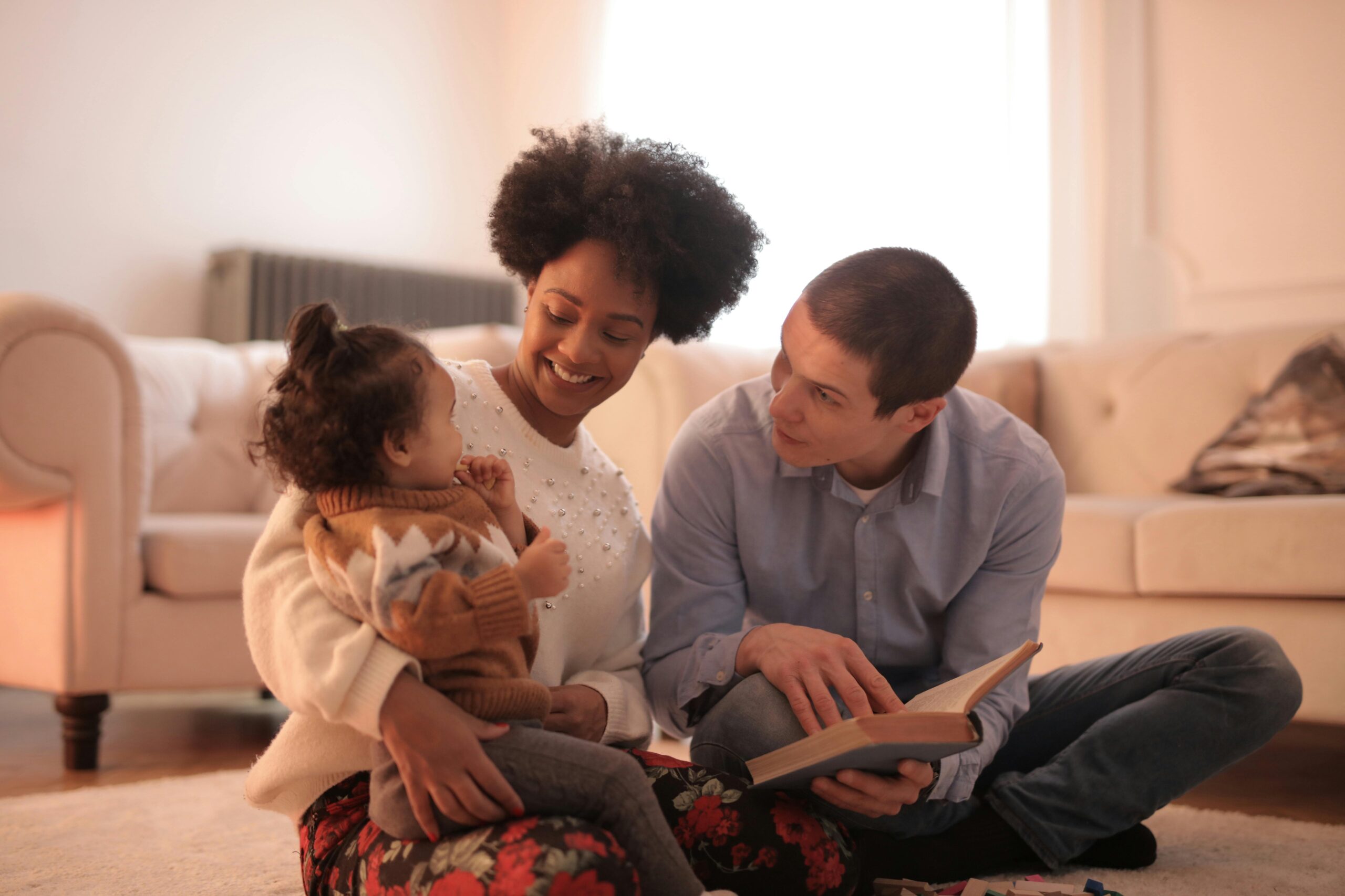 Shows a real relationship between husband, wife and baby while the father is reading a book.