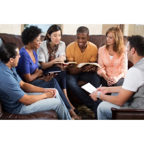 A group or community of people sit together reading the bible happily